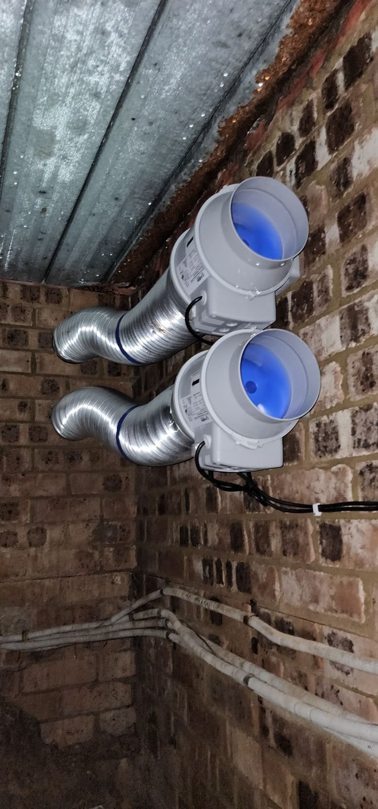 Two white inline fans fixed tight to the joists