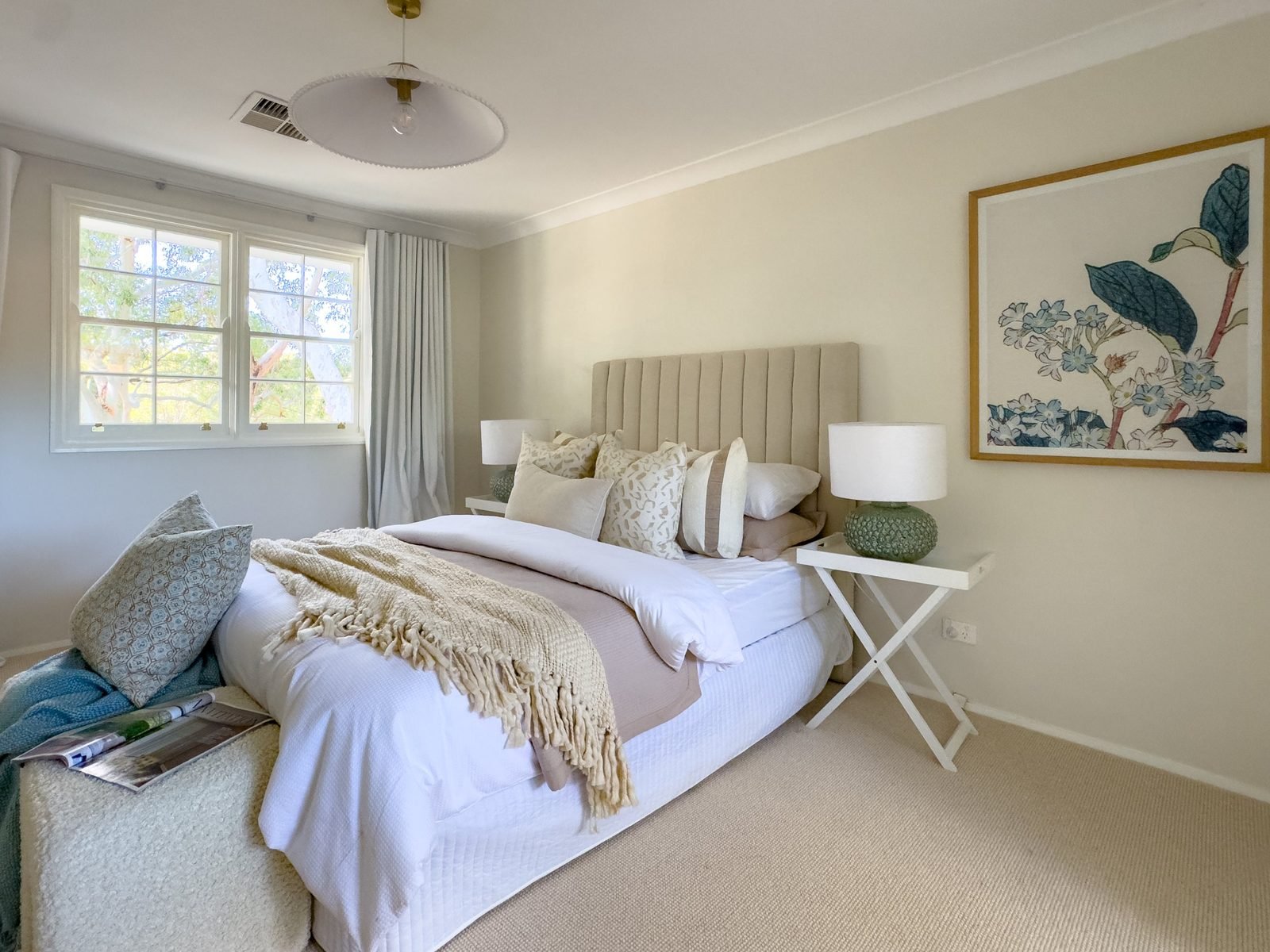 Bedroom with a pendant light above a made bed