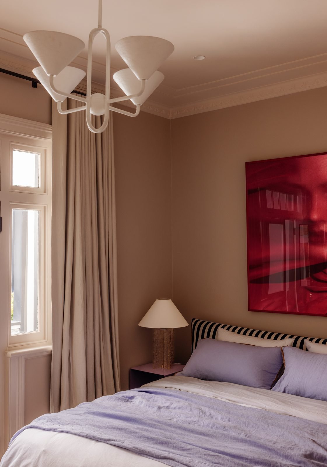 A white chandelier with cone shades in a bedroom